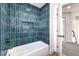 Bathroom with teal tile shower surround and a bathtub at 9031 Aldershot Ct, Las Vegas, NV 89147