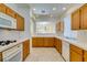 Galley kitchen with wood cabinets and tile counters at 2379 Brockton Way, Henderson, NV 89074