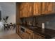 Modern kitchenette with rustic wood cabinets and dark countertops at 6860 Milos Rd, Las Vegas, NV 89118