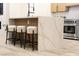 Kitchen island with white marble countertop and black metal stools at 10369 Niagara Falls Ln, Las Vegas, NV 89144