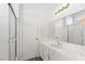 Bright bathroom with white vanity, shower, and updated flooring at 9515 Parvin St, Las Vegas, NV 89123