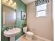 Small bathroom with pedestal sink and green accent wall at 1918 Molly Brook Dr # Lot 5, North Las Vegas, NV 89084