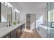 Modern bathroom with double vanity, soaking tub, and glass shower at 4623 Harvest Night St, Las Vegas, NV 89129