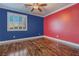 Well-lit bedroom with blue and red walls and wood flooring at 8801 Crescent Lake St, Las Vegas, NV 89113