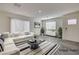 Virtually staged living room with gray floors and a comfy sectional sofa at 10079 Dazzling Sunrays Ave # 0, Las Vegas, NV 89129