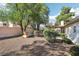 Landscaped backyard with covered patio and stone wall at 6065 Shadow Oak Dr, North Las Vegas, NV 89031