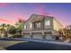 Tan three-car garage home with balcony and desert landscaping at 6624 Lavender Lilly Ln # 1, North Las Vegas, NV 89084