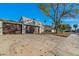 A two-car garage with brown doors and a tree in the front yard at 3056 Garnet Ct, Las Vegas, NV 89121