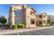 Tan two-story building with red tile roofs, landscaping, and parking at 520 Arrowhead Trl # 911, Henderson, NV 89015