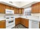 Kitchen with wood cabinets, white appliances, and tile countertops at 520 Arrowhead Trl # 911, Henderson, NV 89015