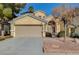 Tan two-story house with a two-car garage and nicely landscaped yard at 5024 Glittering Star Ct, Las Vegas, NV 89130