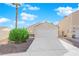 Single-story house with a white garage door and landscaped front yard at 8221 Ten Gallon Ct, Las Vegas, NV 89129