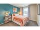 Guest bedroom with teal walls, a metal bed frame, and peach bedding at 9380 Serene Harbor St # Lot 27, Las Vegas, NV 89178