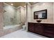 Bathroom with soaking tub, glass shower, and dark wood vanity at 1504 Castle Wall St, Las Vegas, NV 89117