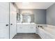 Bathroom with double vanity, soaking tub, and marble tile accents at 511 Bass Dr # C, Henderson, NV 89014