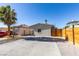 Front view of a charming house with a gray exterior, wood fence, and ample parking at 302 Vandalia St, Las Vegas, NV 89106