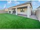 Artificial turf backyard with covered patio and block wall at 54 Barton Bay Ave, North Las Vegas, NV 89031