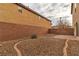 Landscaped backyard with gravel, brick patio, and a small plant at 10731 Mason Hill Ave, Las Vegas, NV 89166