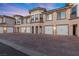 Building exterior with attached garages and brick driveway at 20 Via Visione # 104, Henderson, NV 89011