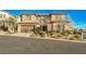 Two-story house with stone exterior, large windows, and a three-car garage at 12002 Tramonto Ave, Las Vegas, NV 89138