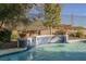 Stunning blue-tiled water feature cascades into the pool at 12002 Tramonto Ave, Las Vegas, NV 89138