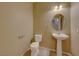 Guest bathroom with pedestal sink and toilet at 209 Turkey Creek Way, Henderson, NV 89074