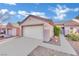 Single-story house with a beige exterior, attached garage, and landscaped front yard at 2157 Point Mallard Dr, Henderson, NV 89012