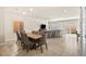 Bright dining room features a large wooden table with gray chairs, and views into the living room and kitchen at 8937 Pelican Point St, Las Vegas, NV 89178