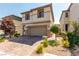 Two-story house with a tan exterior, stone accents, and a two-car garage at 10039 Silver Comet Ct, Las Vegas, NV 89178