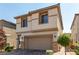 Two-story house with a tan exterior, stone accents, and a two-car garage at 10039 Silver Comet Ct, Las Vegas, NV 89178