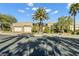 Tan colored house with three car garage, and a large palm tree in front at 10254 Sofferto Ave, Las Vegas, NV 89135