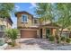 Two-story house with brown garage door and landscaping at 10554 Cloud Whisper Dr, Las Vegas, NV 89135