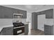 Modern kitchen with gray cabinets, white herringbone backsplash, and stainless steel appliances at 4240 Laurel Hill Dr, North Las Vegas, NV 89032