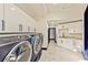 Modern laundry room with white cabinets and marble floors at 8625 Scarsdale Dr, Las Vegas, NV 89117