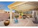 Relaxing backyard patio with pergola, stone pavers, and comfortable seating at 9116 Ironstone Ave, Las Vegas, NV 89143