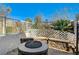 Cozy backyard firepit with stone seating wall and lattice fencing at 10146 Robins Hollow Rd, Las Vegas, NV 89183