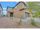 Two-story house with a brown exterior, stone accents, and a paved driveway at 139 Fulgora St, Henderson, NV 89074