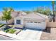 Tan two-story house with a white garage door at 2150 Polynesia Cir, Henderson, NV 89074