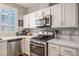 Modern kitchen with white cabinets, stainless steel appliances, and quartz countertops at 2150 Polynesia Cir, Henderson, NV 89074