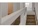 Modern staircase with a glass and white wall feature, leading to the upper level at 6007 Whitmire Ave, Las Vegas, NV 89139