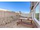 Small backyard with gravel landscaping and wooden patio table at 6570 Coffee Theme St # Lot 5, North Las Vegas, NV 89084