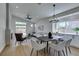 Elegant dining area with modern chandelier, black table, and comfy gray chairs at 10976 Salernes St, Las Vegas, NV 89141