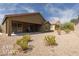 Back exterior view of house with covered patio and desert landscaping at 1361 White Water Way, Mesquite, NV 89034