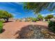 Backyard landscape with a rock pathway and mature trees at 5865 N Conquistador St, Las Vegas, NV 89149