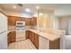 Kitchen with wood cabinets, white appliances, and tile floors at 5950 Barbosa Dr # 8, North Las Vegas, NV 89031