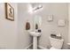 Small bathroom with pedestal sink, toilet, and framed artwork at 10558 El Camino Rd, Las Vegas, NV 89141