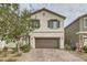 Two-story house with brown garage door and landscaped front yard at 10558 El Camino Rd, Las Vegas, NV 89141