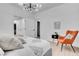 Modern bedroom with an orange accent chair and large bed at 10852 Avenzano St, Las Vegas, NV 89141