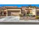 Tan stucco house with two car garage and desert landscaping at 2133 Hallston St, Las Vegas, NV 89134