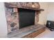 Stone fireplace with a rustic wooden mantel and hearth at 2404 Camelia Cir, Las Vegas, NV 89108